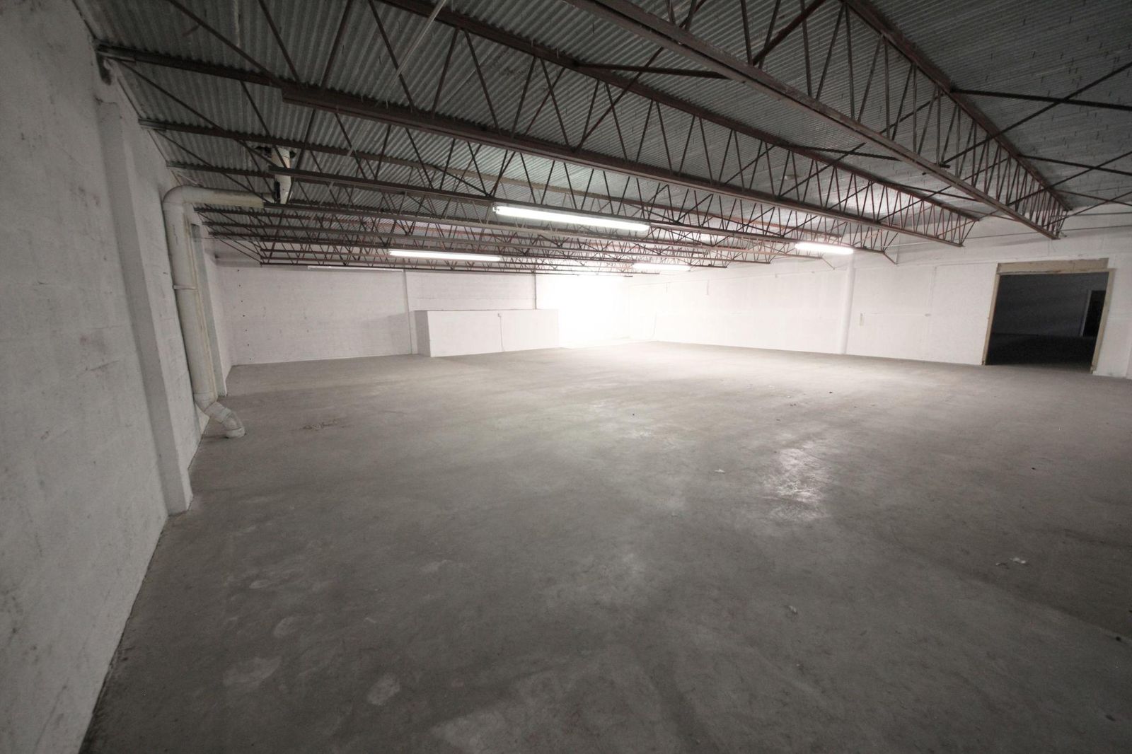 Concrete mezzanine level beneath an exposed steel roof structure
